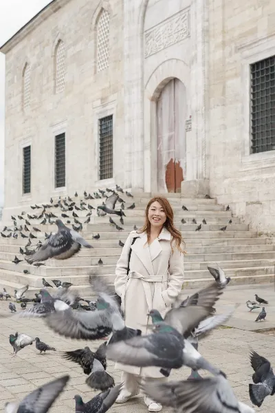 Travel Portrait Surrounded by Pigeons at Mosque Courtyard