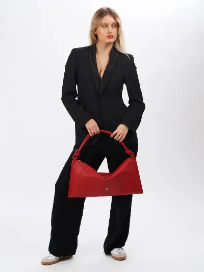 Minimalist Studio Fashion Model in Black Suit with Red Handbag